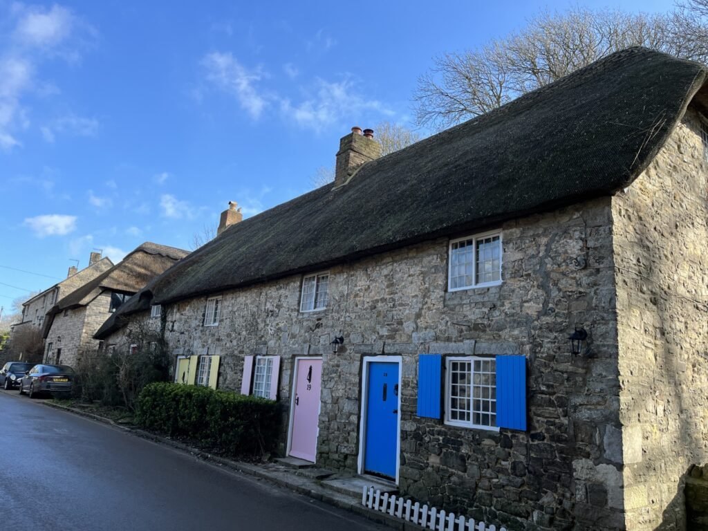 Honeysuckle Holiday Cottage in West Lulworth, Dorset - part of a bank of four cottages with colourful front doors
