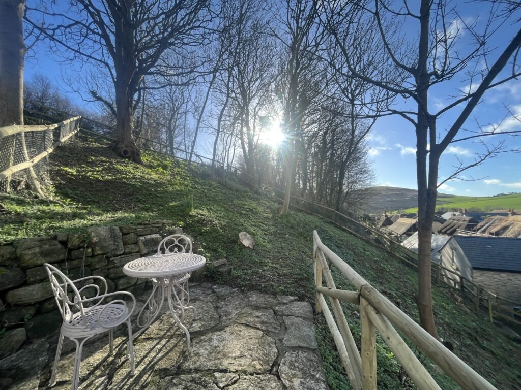 the patio garden of Honeysuckle Holiday Cottage in West Lulworth with views overlooking the village and thatched cottages