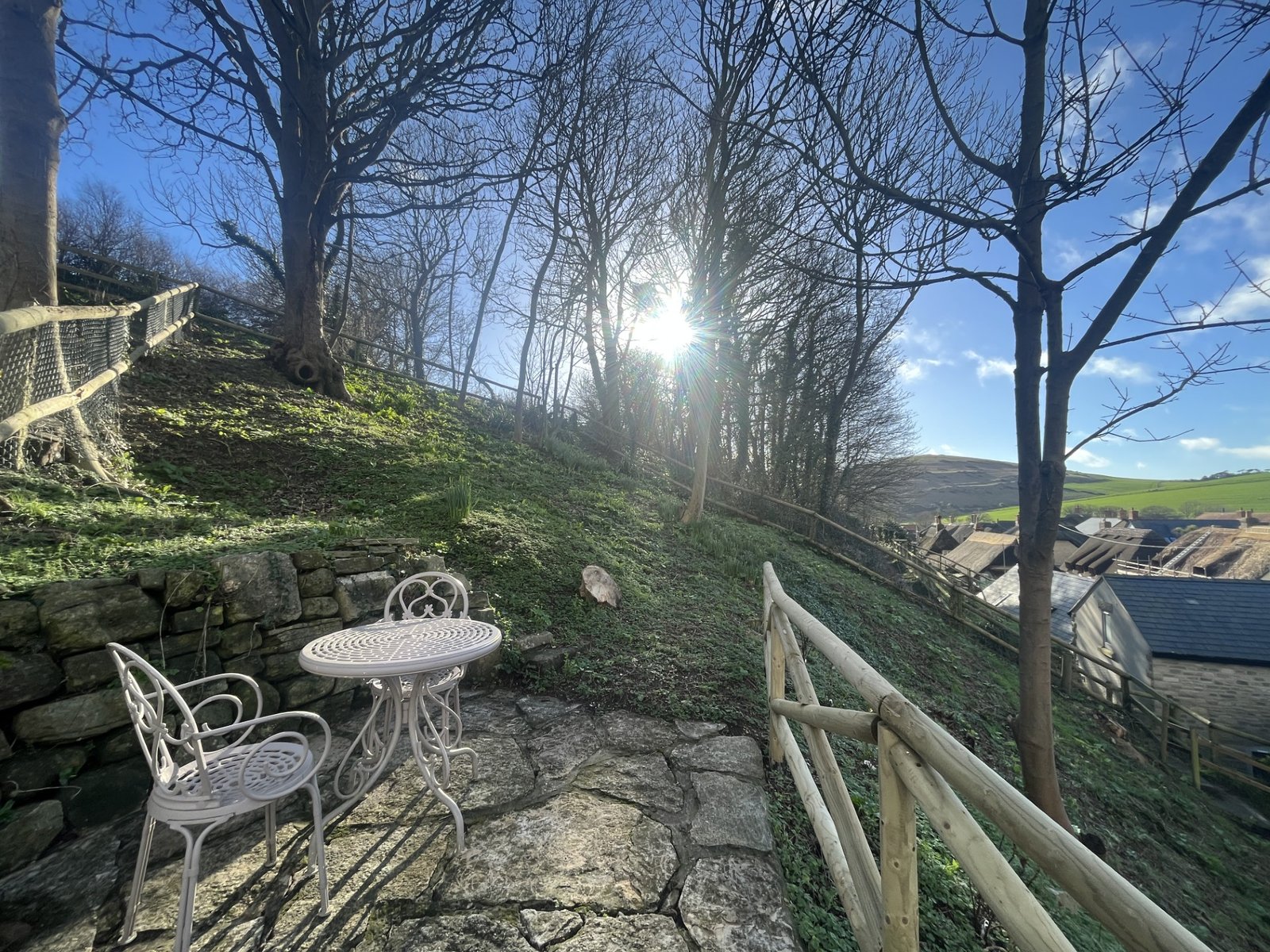 the patio garden of Honeysuckle Holiday Cottage in West Lulworth with views overlooking the village and thatched cottages
