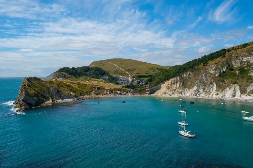 Lulworth Cove from the Sea with boats in the ocean