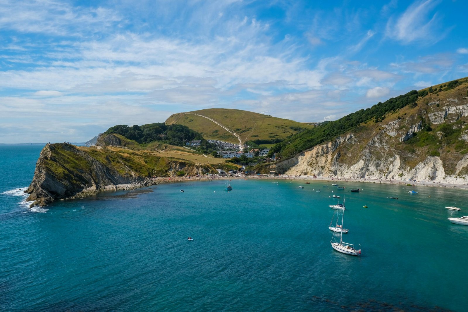 Lulworth Cove from the Sea with boats in the ocean
